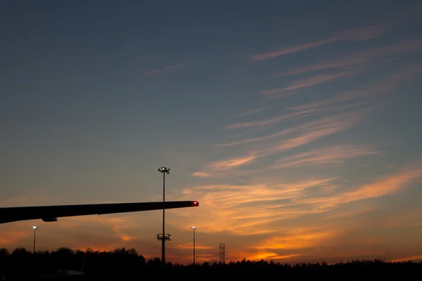 Silhueta asa plana contra o céu por do sol — Fotografia de Stock