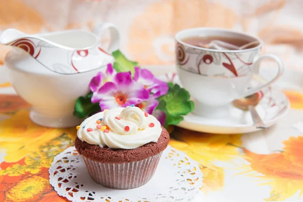 Pastel dulce con taza de té y flores — Foto de Stock