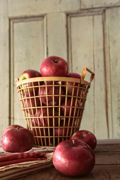 Red apples in metal basket on kitchen table — Stock Photo, Image