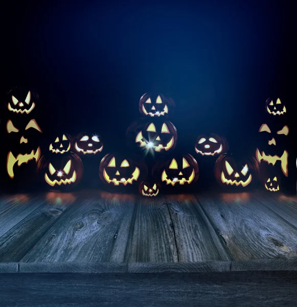 Calabazas de Halloween en un fondo oscuro y suelo de madera —  Fotos de Stock