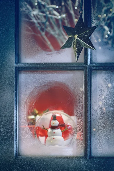 Frosted venster met Kerstdecoratie binnen — Stockfoto