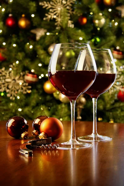 Copas de vino tinto en la mesa con árbol de Navidad — Foto de Stock