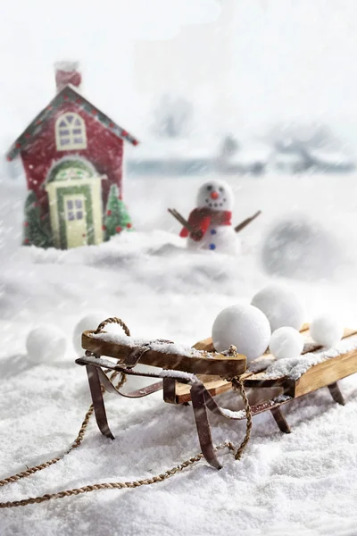 Houten slee en sneeuwballen met winterse achtergrond — Stockfoto