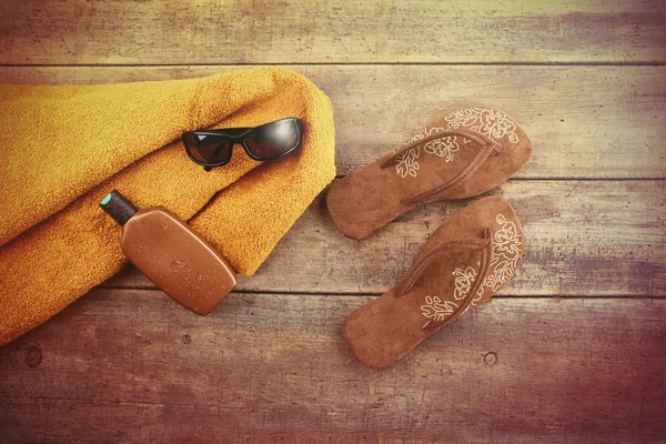 Toalla naranja y artículos de playa en madera — Foto de Stock