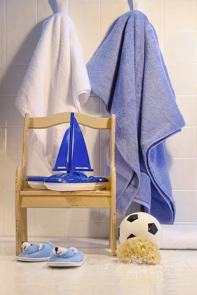 Giocattoli con sedia e asciugamani sul pavimento del bagno — Foto Stock