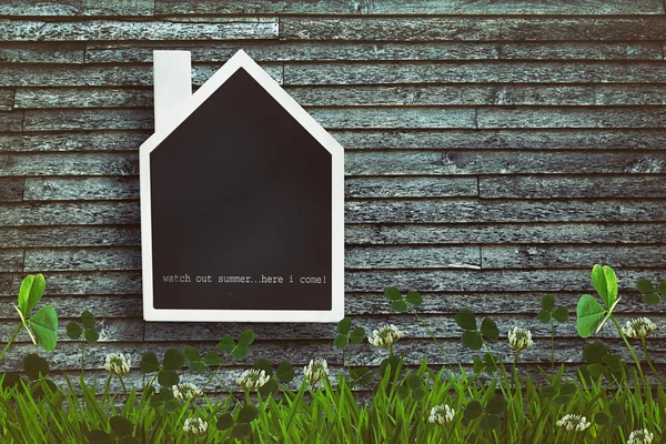 House shaped chalkboard on wooden background — Stock Photo, Image