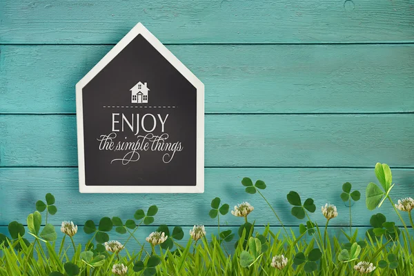 House shaped chalkboard and grass on wood — Stock Photo, Image