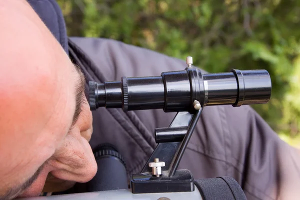 Man looks through a telescope — Stock Photo, Image