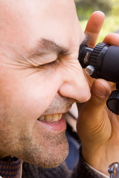 Människan tittar genom ett teleskop — Stockfoto