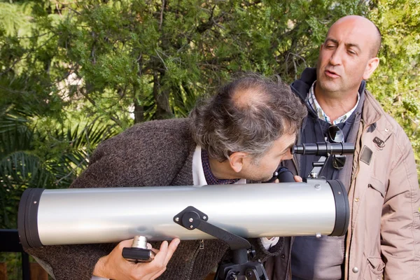 Dois homens olham através do telescópio — Fotografia de Stock