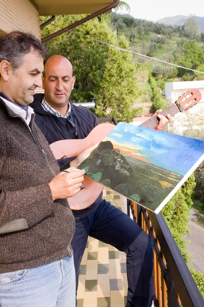 Man schetst een beeld wanneer zijn vriend gitaarspelen — Stockfoto