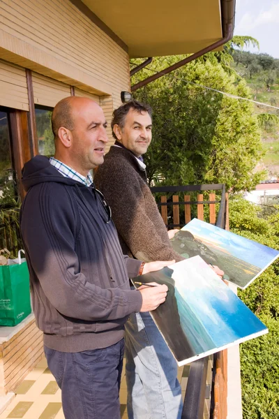 Dos hombres pintan un cuadro — Foto de Stock