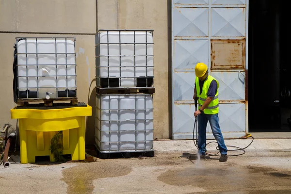 Worker in hard hat pressure washing — Stock Photo, Image