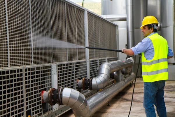 Worker in hard hat pressure washing — Stock Photo, Image