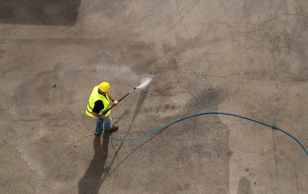 Worker in hard hat pressure washing — Stock Photo, Image