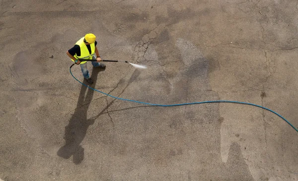 Worker in hard hat pressure washing — Stock Photo, Image