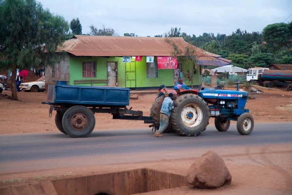 Tanzanian local people pushing tractor — Stock Photo, Image