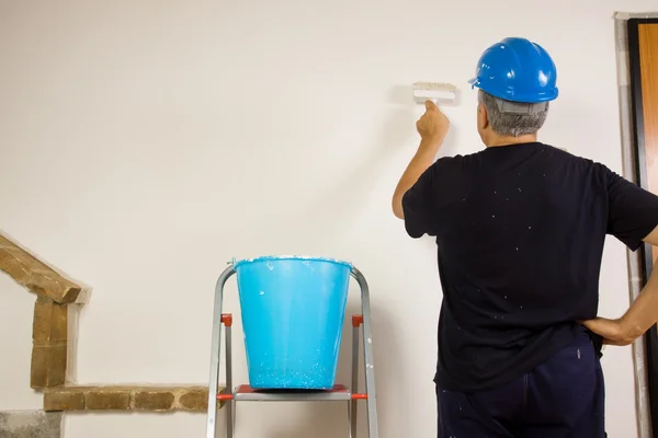 Worker paints the wal with a brush — Stock Photo, Image