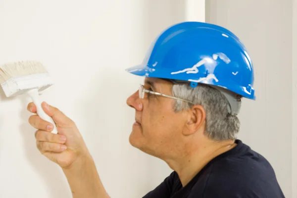 Werknemer verft de muur met een borstel — Stockfoto