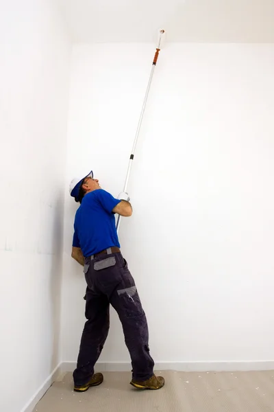 Werknemer schildert het plafond met een anker roller — Stockfoto