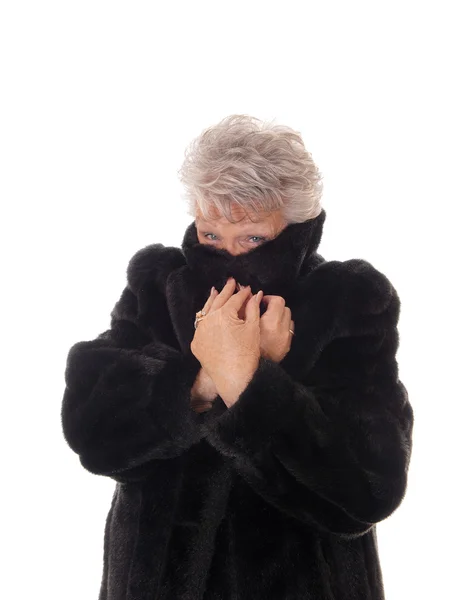 Senior woman hiding in her fur coat. — Stock Photo, Image