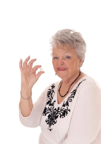 Senior woman holding vitamin pill. — Stock Photo, Image