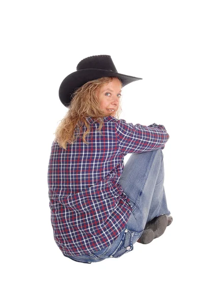 Härlig kvinna som sitter på golvet med hatt. — Stockfoto