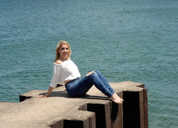 漂亮的女孩坐在码头上湖. — 图库照片