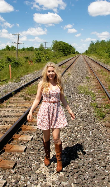 Mujer joven caminando por las vías del ferrocarril . — Foto de Stock