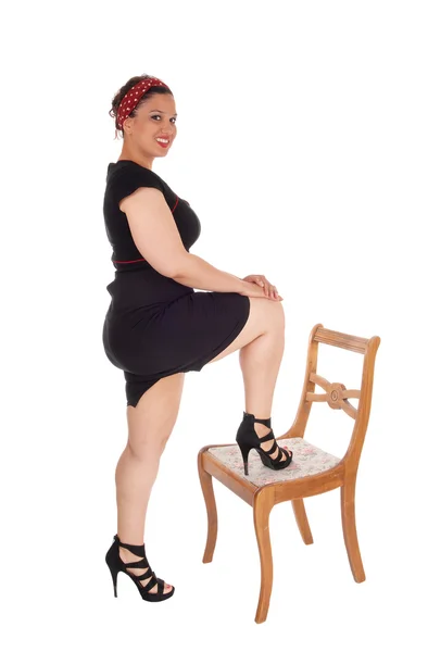 Woman standing leg on chair. — Stock Photo, Image