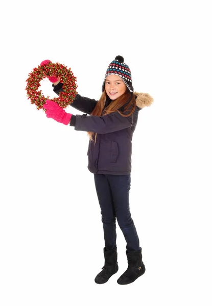 Girl holding a wreath up. — Stock Photo, Image