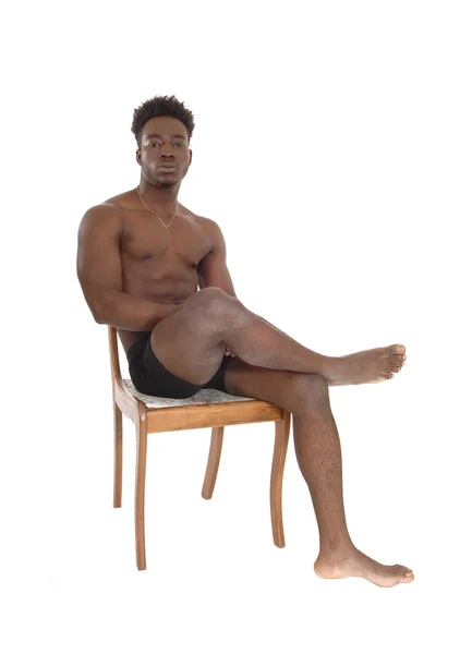 Afrikaanse man zit op stoel. — Stockfoto
