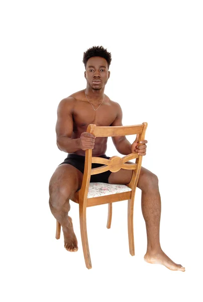 Czarny człowiek siedzi na krześle. — Zdjęcie stockowe