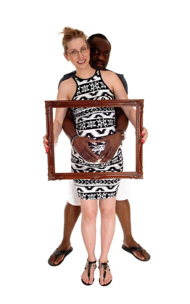 Pregnant couple with picture frame. — Stock Photo, Image