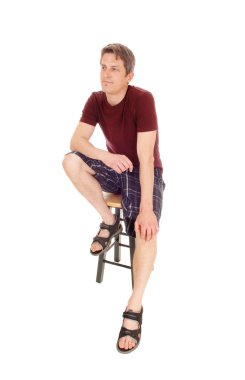 Şort oturan genç adam.