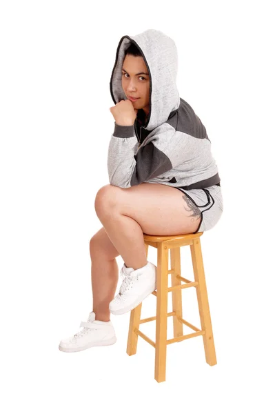 Flickan sitter i hoodie på en stol. — Stockfoto