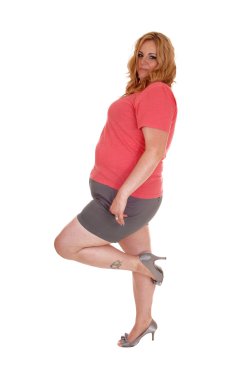 Artı boyutu kadın şort ve topuklu ayakta.