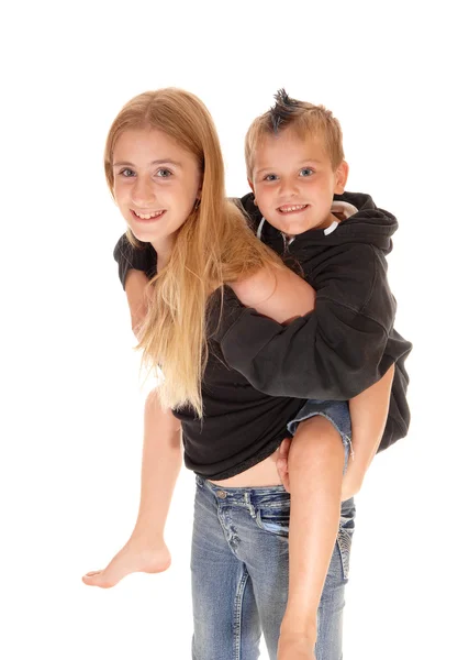 Young pretty girl is piggybacking little brother. — Stock Photo, Image