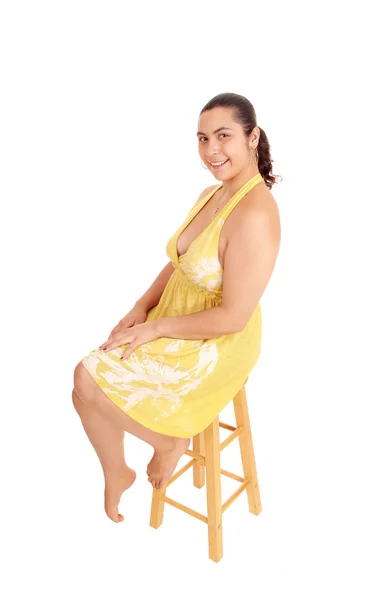 Mulher de vestido amarelo sentado na cadeira . — Fotografia de Stock