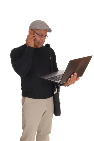 Een Spaanse man aan het werk op zijn laptop. — Stockfoto