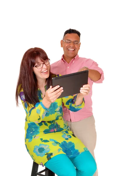 Paar mittleren Alters amüsiert sich mit dem Tablet. — Stockfoto