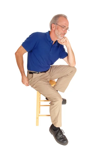 Старик сидит на стуле и думает: . — стоковое фото