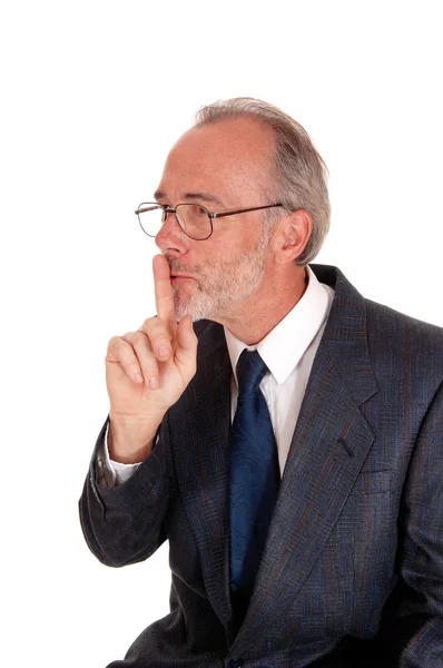 Businessman giving sign with finger over mouth. — Stock Photo, Image