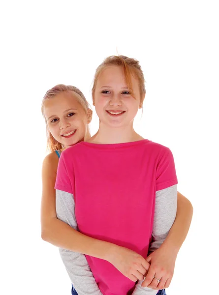 Sonrientes hermanas de pie detrás de la otra . —  Fotos de Stock