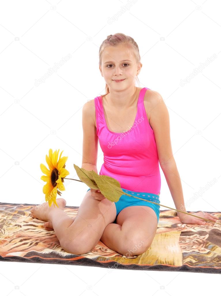 Young girl sitting in bathing suit on a towel.