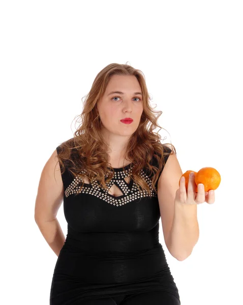Blond woman holding two oranges. — Stock Photo, Image