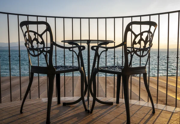 Terrasse mit Blick auf den See mit Stühlen und Tisch lizenzfreie Stockbilder