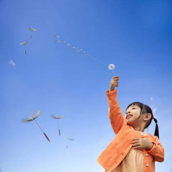 Girl with is holding dandelion in hand while standing — Stock Photo, Image