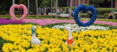 Taipei, Taiwan, February 26 2021: Decorative dutch mill and a boat with two characters at Shilin residence park entrance for the Tulip Show 2021