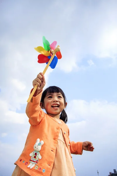 可爱的小女孩，在夏日的草地上举行风车 — 图库照片